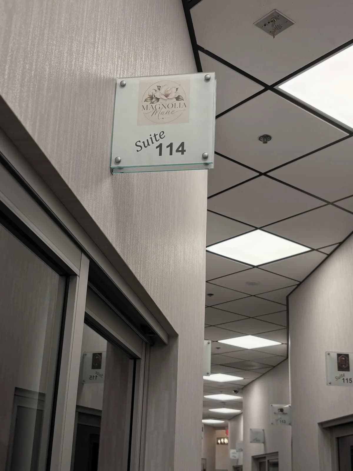 Frosted-glass Suite 114 door sign marking the entrance to Magnolia Mane in Goodyear, AZ